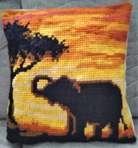 tapestry cushion with elephant silhouette against a sunset