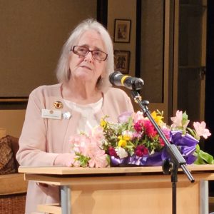 Angela Chessman standing at a lectern at the ACM